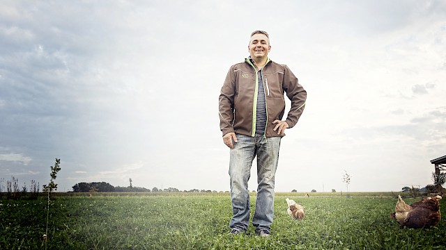 Portrait von Anton Ziesel auf einem Feld mit Hühnern