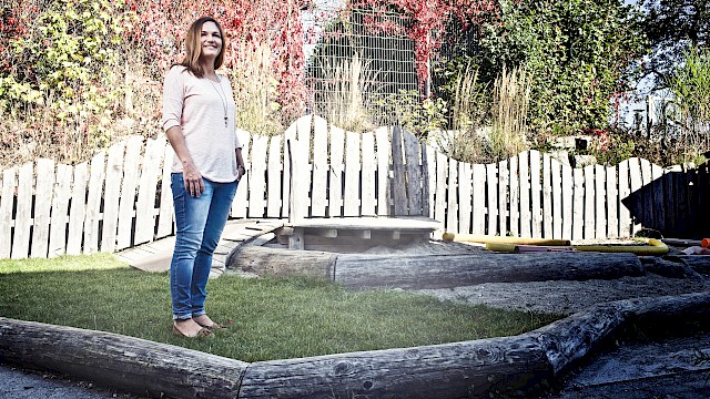 Erzieherin auf dem Spielplatz mit Sandkasten der Kinderkrippe Bonlanden