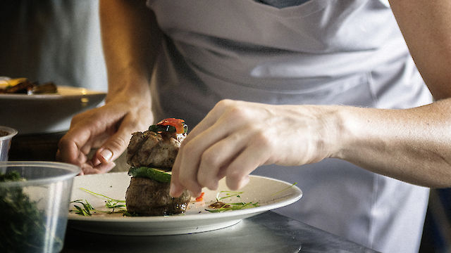 Teller auf dem von einer Person essen angerichtet wird