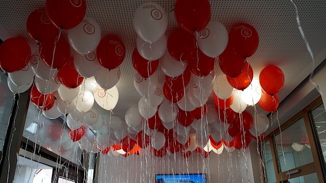 Rote und Weiße Luftballons mit dem Wir sind Berkheim Logo die im Rathaus an der Decke schweben