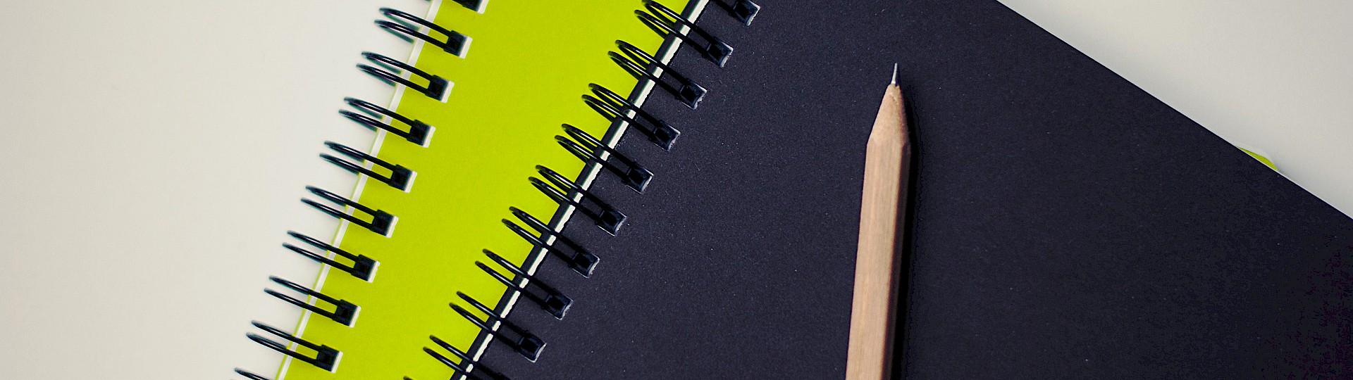 Grüner und Schwarzer Schreibblock mit einem Bleistift